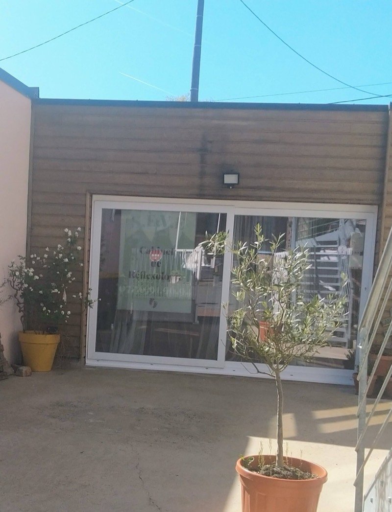 Façade en bois du cabinet S.È.V.E Réflexologie à Don, face au parking de l'église